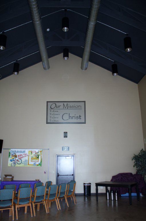 A large room with a sign on the wall that says our mission christ