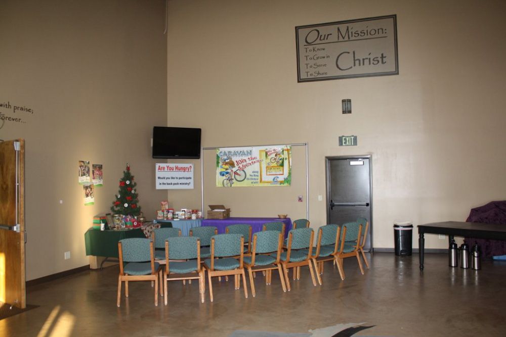 A large room with chairs and a sign that says our mission christ
