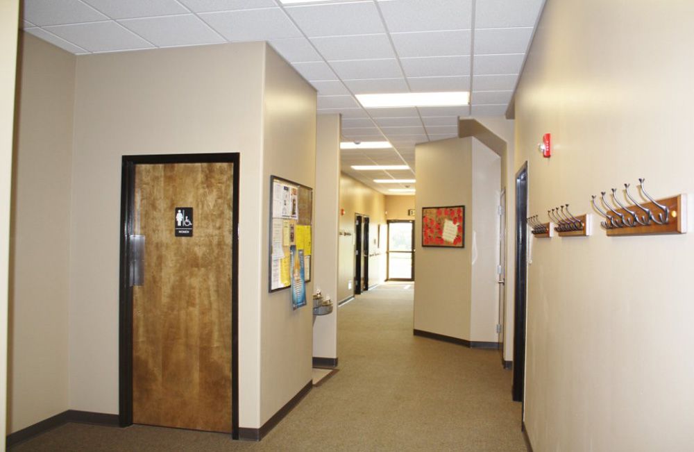 A hallway with a wooden door and hooks on the wall